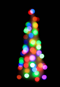 从黑色背景上隔离的彩色灯圣诞树