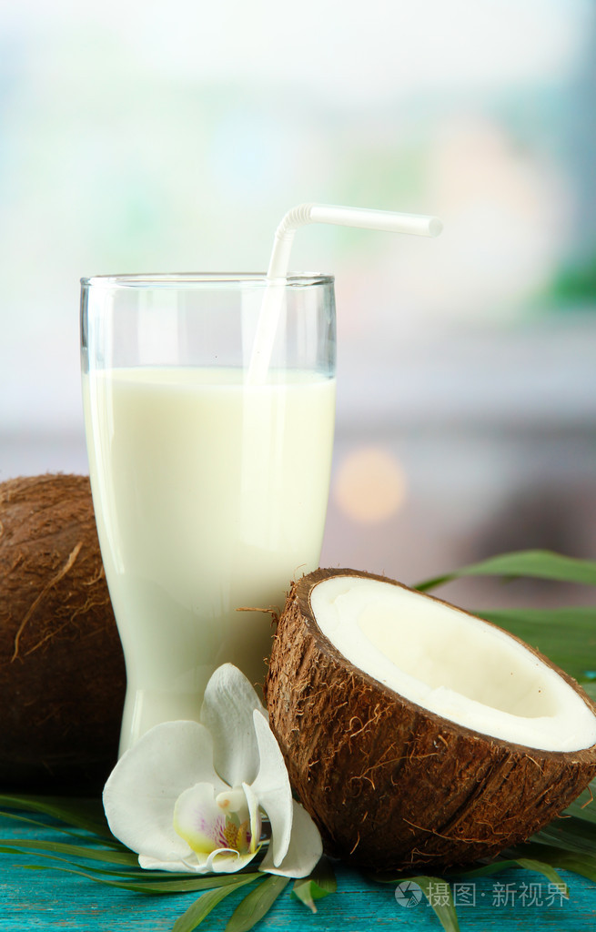 一杯牛奶蓝色木桌子上椰子