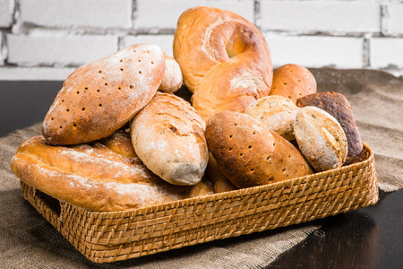 各种类型的新鲜面包在一个篮子的桌子上, 砖 backg