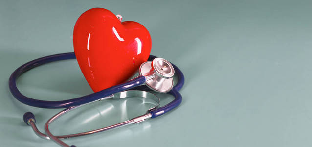 红色心脏与听诊器在蓝色木背景。复制空间。情人节