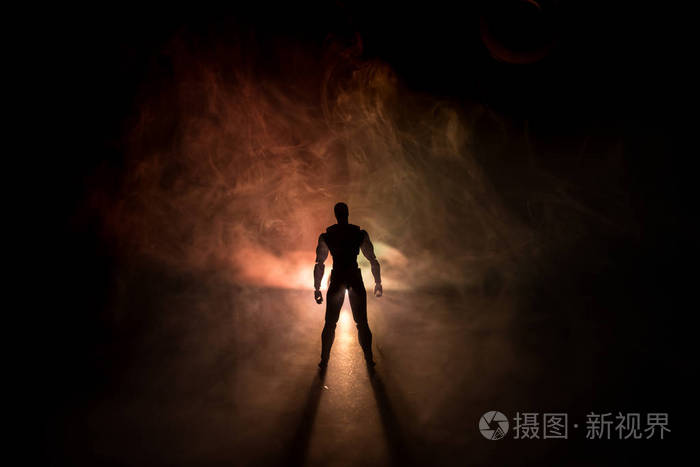 人的剪影站在一个黑暗的雾色调的背景.