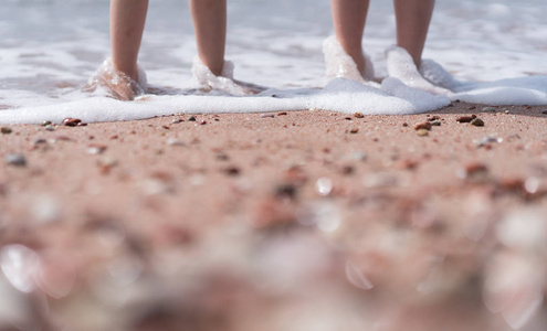 孩子们脚在海边的海水中