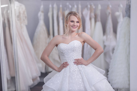 微笑年轻新娘在白色礼服在商店图片