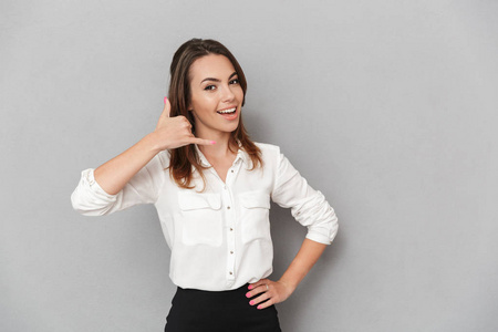 一个自信的年轻的商业妇女的肖像显示呼叫手势孤立的白色背景