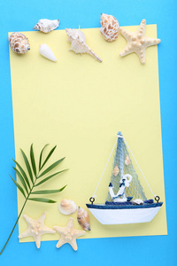 蓝色背景下的贝壳和装饰船的空白纸
