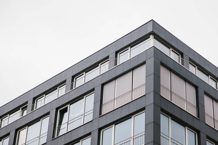 建筑物的角落里有许多窗户, 对着灰色的天空照片