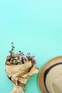 蓝色背景上美丽的花朵和夏天的帽子的顶部视图