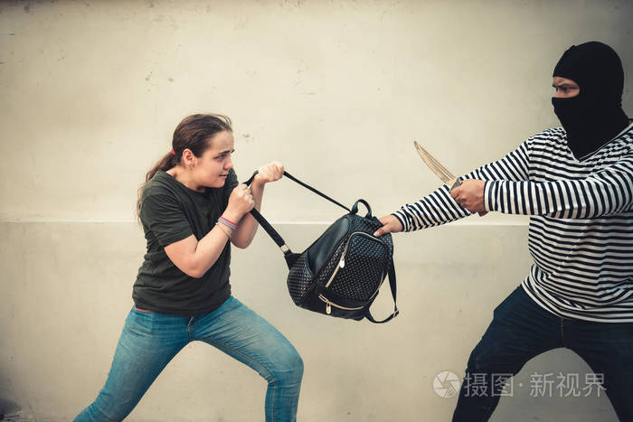 强盗从街上的旅游妇女那里抢包. 小偷抢劫概念
