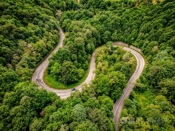 在山上穿过一座森林的极端蜿蜒的公路鸟瞰