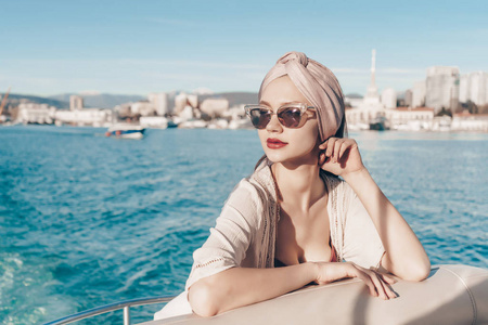 一个豪华的富有的女人在太阳镜放松和休息在她的游艇, 海上航行