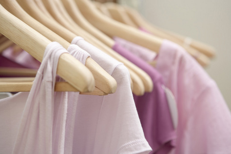 时尚存储区中的木衣架上挂着的粉红色衣服的细节