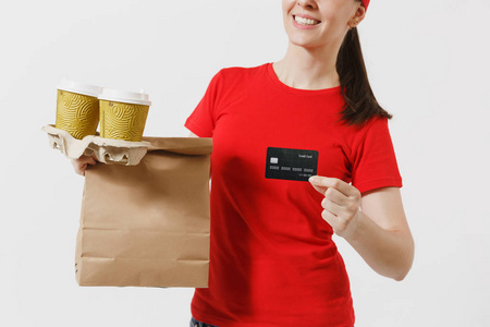 妇女在红色帽子, t恤给快速的食物顺序隔绝在白色背景。女快递持有信用卡, 纸包配食品, 咖啡。从商店或餐馆送到家里的产品
