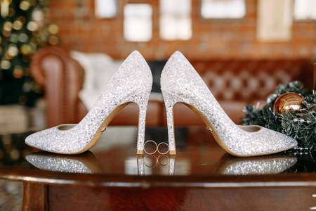 婚礼鞋和婚礼用具, 婚礼金戒指, 婚礼花束在桌上