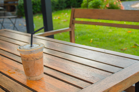 在花园的木桌上放冰咖啡