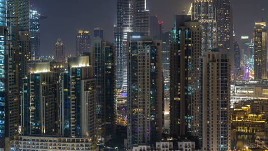 空中城市景观 timelapse 在夜间与照明现代建筑在迪拜市中心, 阿拉伯联合酋长国。从屋顶照明的金融区视图