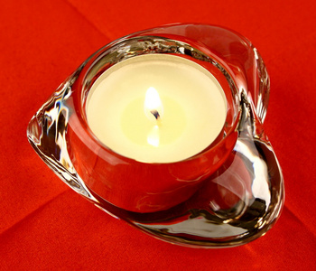 一支蜡烛上红色背景特写的玻璃心