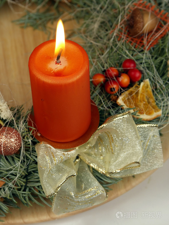 从新鲜树枝和锥状与一支蜡烛的花圈