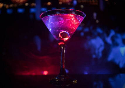 玻璃杯, 里面有橄榄马提尼。在黑暗的雾色调背景下, 关闭玻璃与俱乐部饮料的看法。选择性对焦。俱乐部饮品概念
