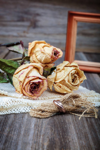 结婚戒指和玫瑰干花木制背景图片