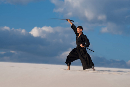 果断的人, 在传统的日本服装用剑, 武士刀, 是训练武术在沙漠期间日落