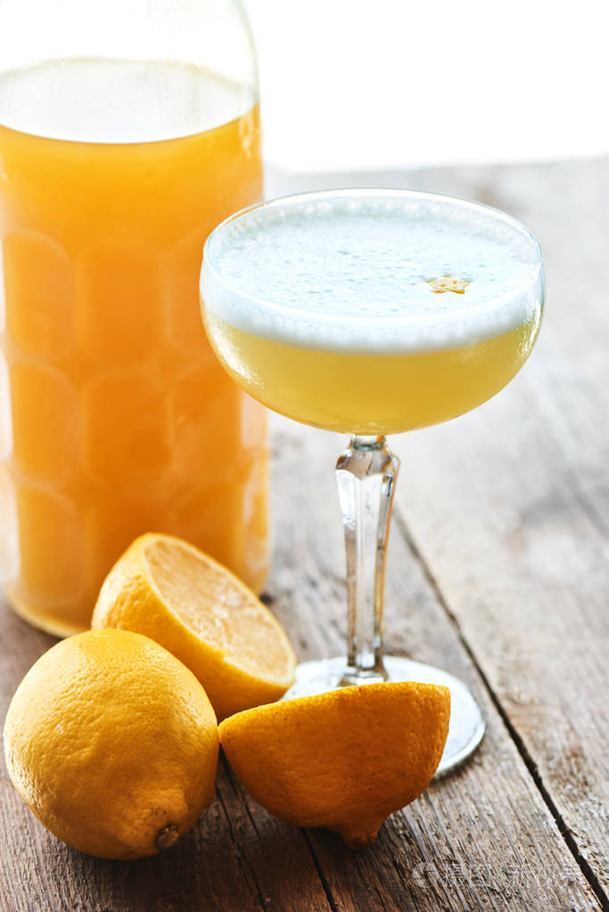 酒精鸡尾酒limoncello萨在酒杯和木桌上的瓶子里供应