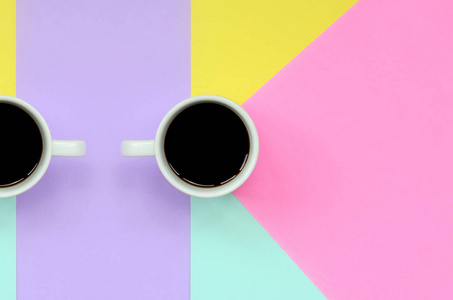 小白咖啡杯的纹理背景的时尚粉彩蓝色, 黄色, 紫罗兰色和粉红色的纸张在极小的概念