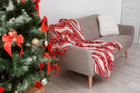 时尚的起居室内装饰圣诞树和舒适的沙发