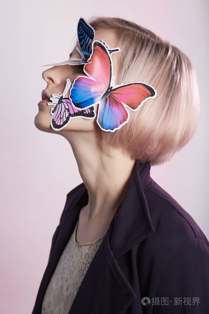 带蝴蝶面具的金发女郎美丽的女孩与蝴蝶在脸上