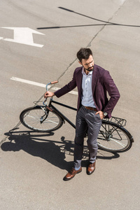 时尚年轻商人的高角度观与老式自行车