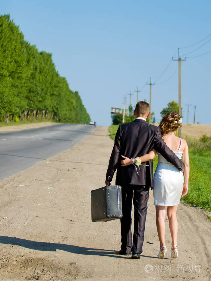 年轻刚结婚的一对走在路上, 回头看照片-正版商用图片05vbvq-摄图新
