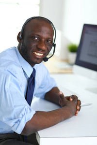 非洲裔美国商人对耳机工作在他的笔记本电脑