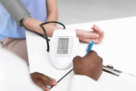 年轻的非裔美国医生检查病人在医院的血压