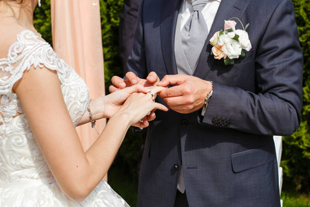 新郎把结婚戒指放在新娘的手指外面
