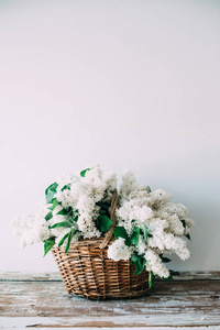 木制柳条篮中的新鲜白丁香花花束