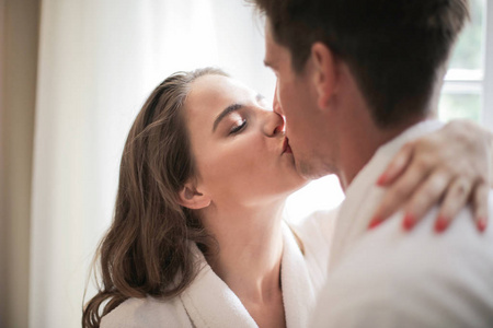 一对年轻情侣在酒店房间接吻
