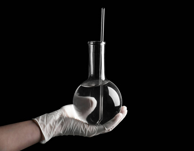 科学家在黑色背景下持有液体的容积烧瓶