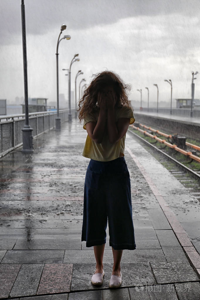 郁闷的年轻女子在雨天户外