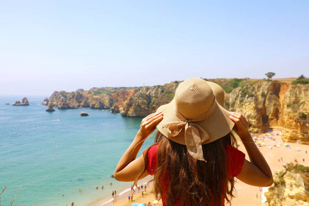 葡萄牙南部拉各斯海滩上, 戴着帽子的女士面对迷人的景色