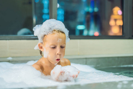 沐浴在窗前满是泡沫的婴儿的肖像照片