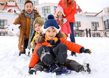 快乐家庭雪橇在雪公园在冬天假期