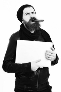 大胡子抱着笔记本电脑和吸烟 sigar 的野蛮白种人时髦