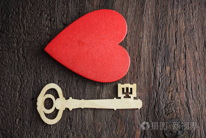 红色心脏和木桌背景的钥匙