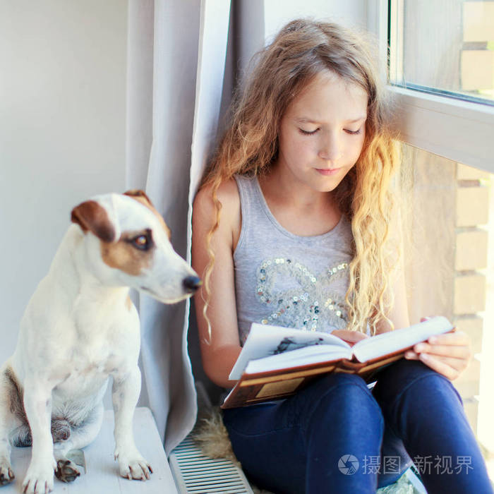 孩子在家里看书。女孩坐在窗口在读