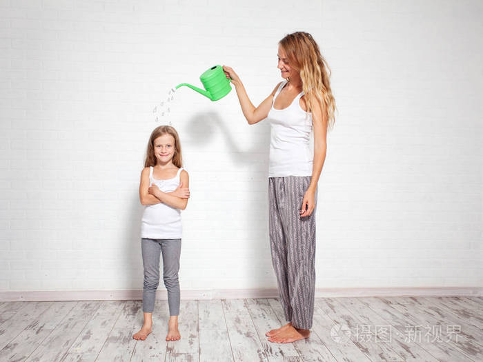 养育孩子女人从浇水罐里倒了一个孩子养育孩子