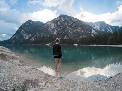 妇女站立反对惊奇的看法 Braies 湖与山脉反射在湖水白云岩阿尔卑斯, 意大利。在 Gopro 英雄 5 hero5 上被俘。