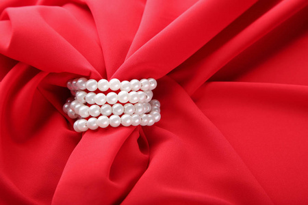 珍珠项链在红色缎纹织品图片