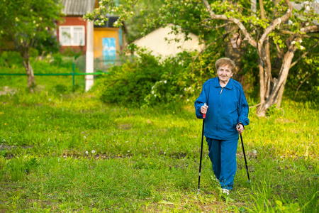 活跃的老妇人北欧在户外散步85岁