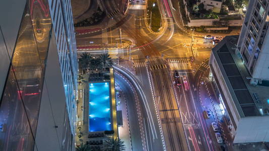 在一个大城市的夜晚 timelapse 的道路交叉路口的鸟瞰图。阿联酋迪拜滨海区城市景观与汽车摩天大楼和电车线路