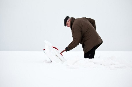 男子用铁铲除雪