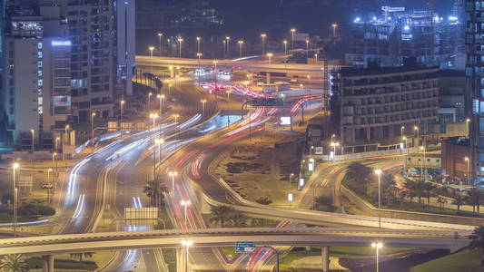 在一个大城市的夜晚 timelapse 的道路交叉路口的鸟瞰图。阿联酋迪拜滨海区城市景观与汽车和摩天大楼